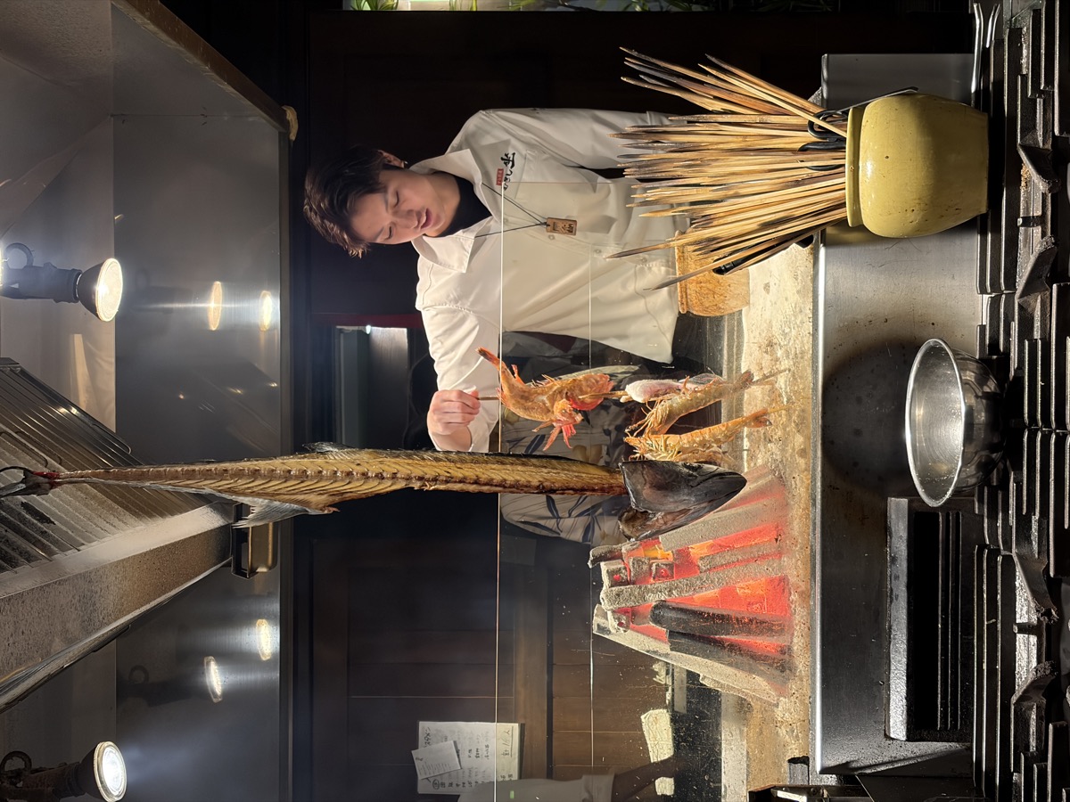 셰프가 화로 앞에서 생선을 굽는 모습